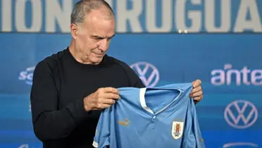 Marcelo Bielsa sosteniendo la camiseta de Uruguay.