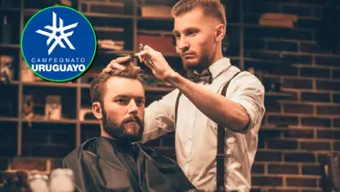 Barbero cortando el pelo junto al logo del Campeonato Uruguayo.