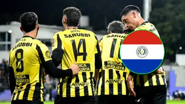 Jugadores de Peñarol y la bandera de Paraguay.