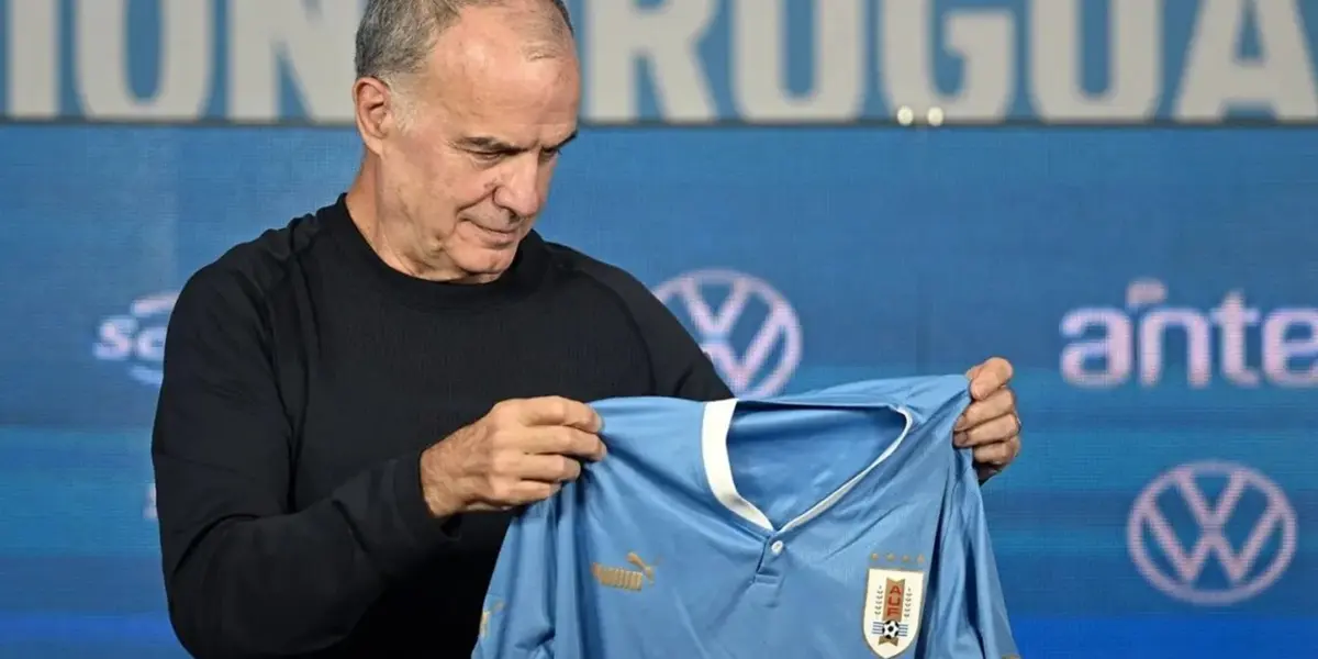 Marcelo Bielsa sosteniendo la camiseta de Uruguay.